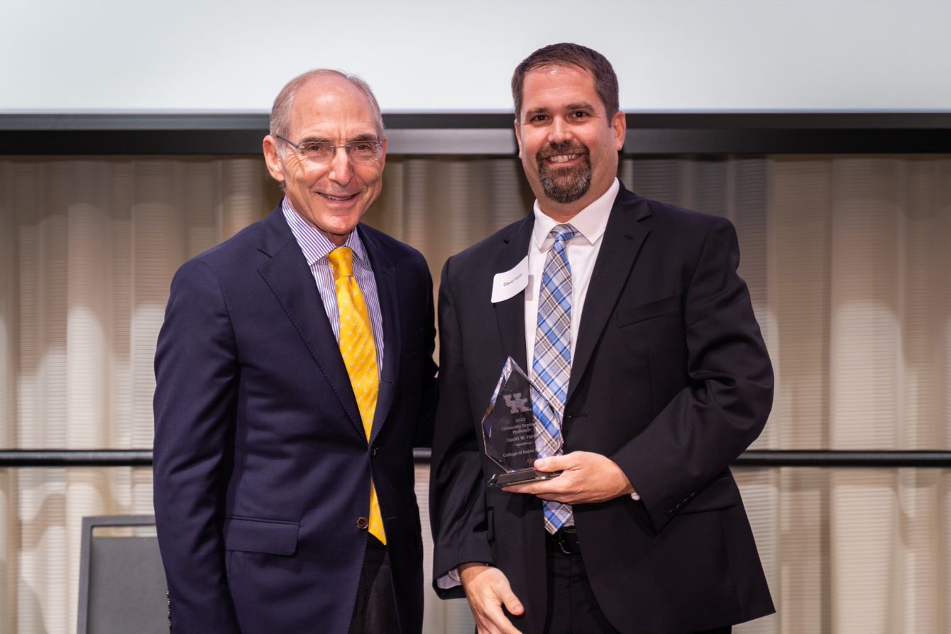 a photograph of Dr. Dave Fardo holding the "2022-2023 UK Research Professorship Award" with President Capilouto