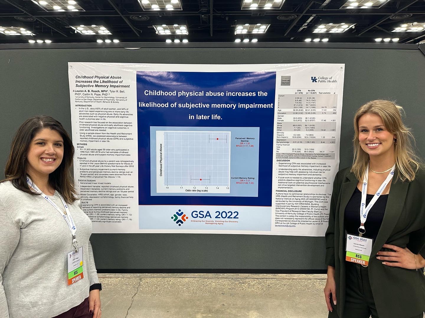picture of Caitlin Pope and Lauren Roach standing in front of a research poster