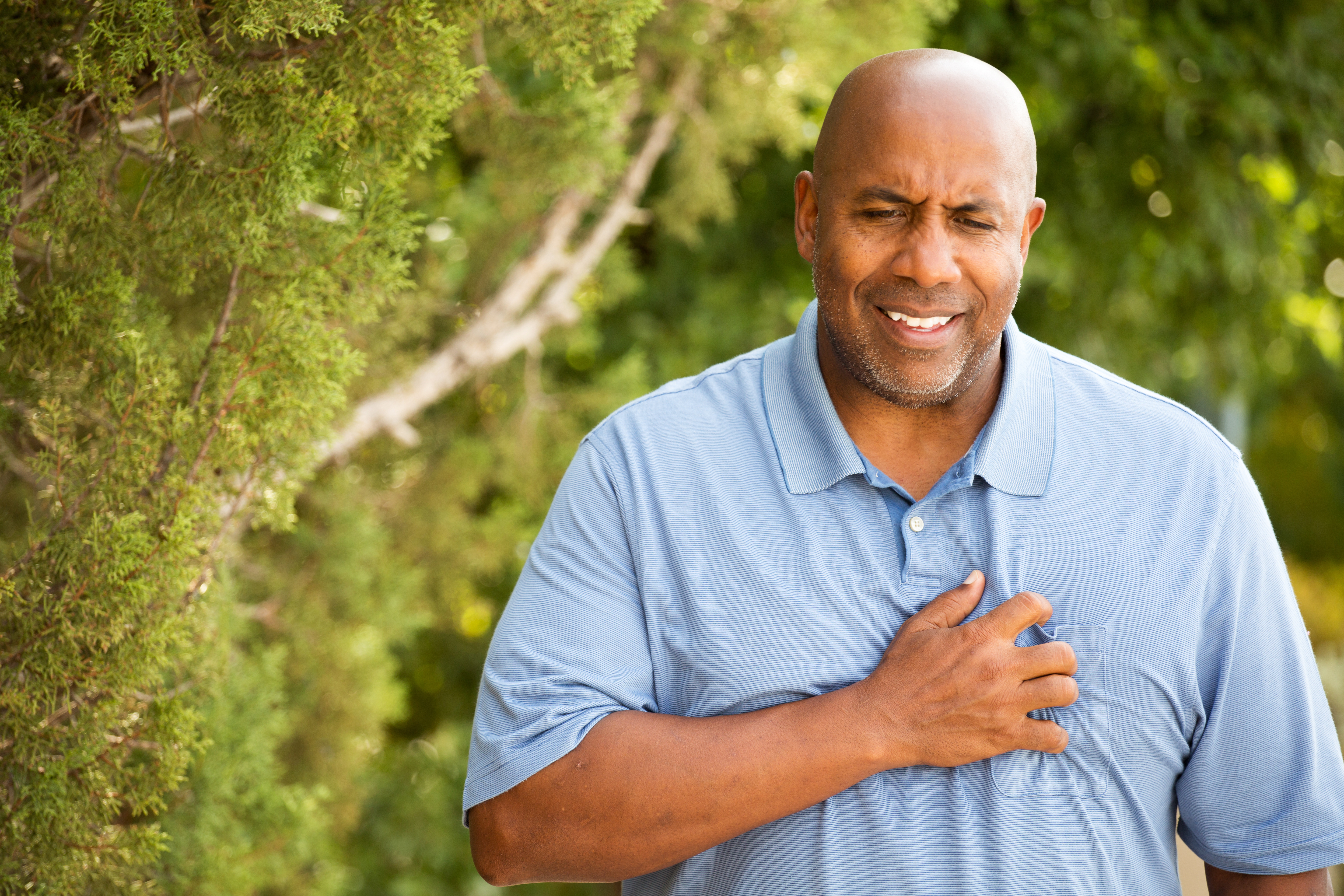 a photograph of an African American male holding hand over heart