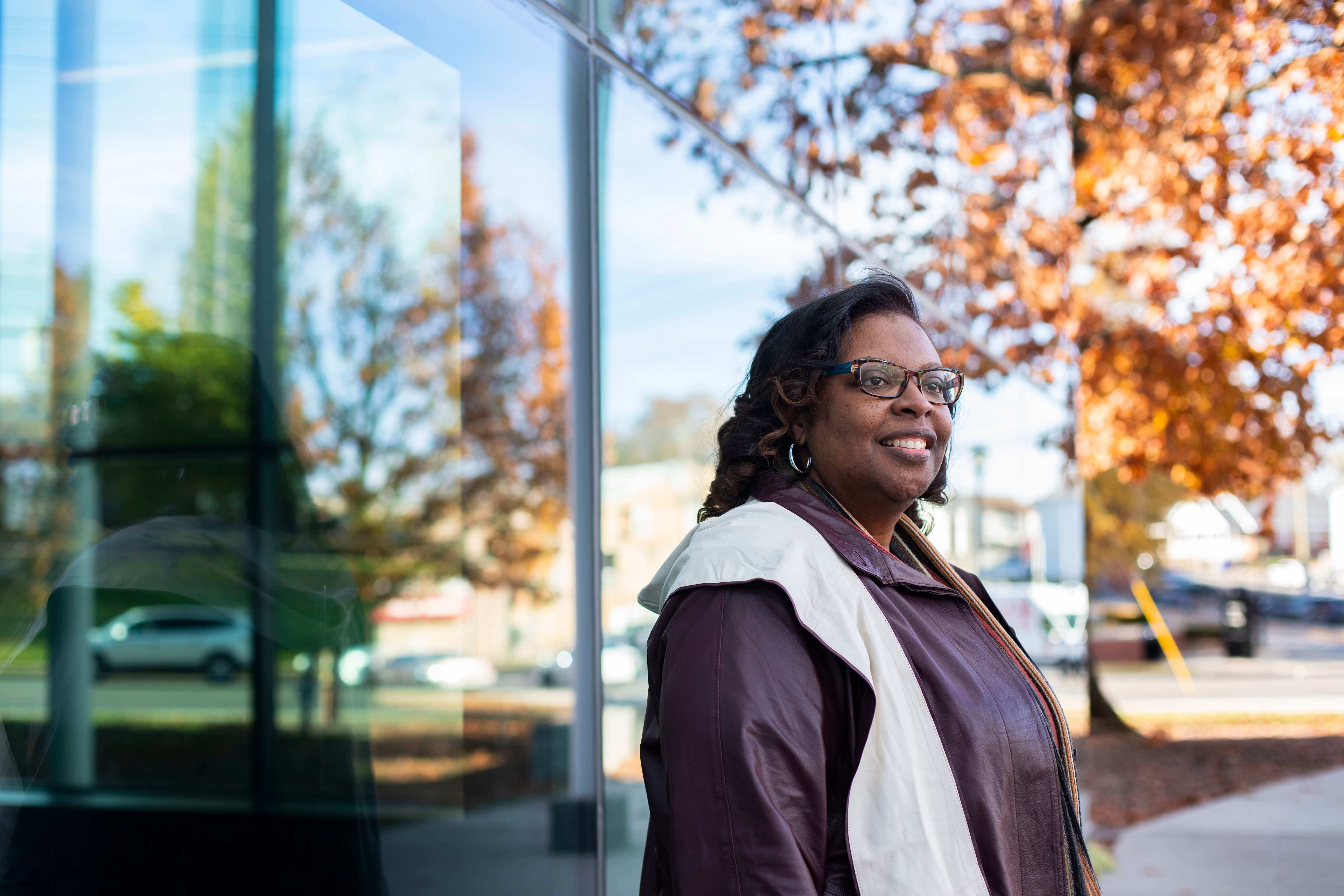 Professional picture of Dr. Regina Washington standing outside on UK's campus in graduation regalia