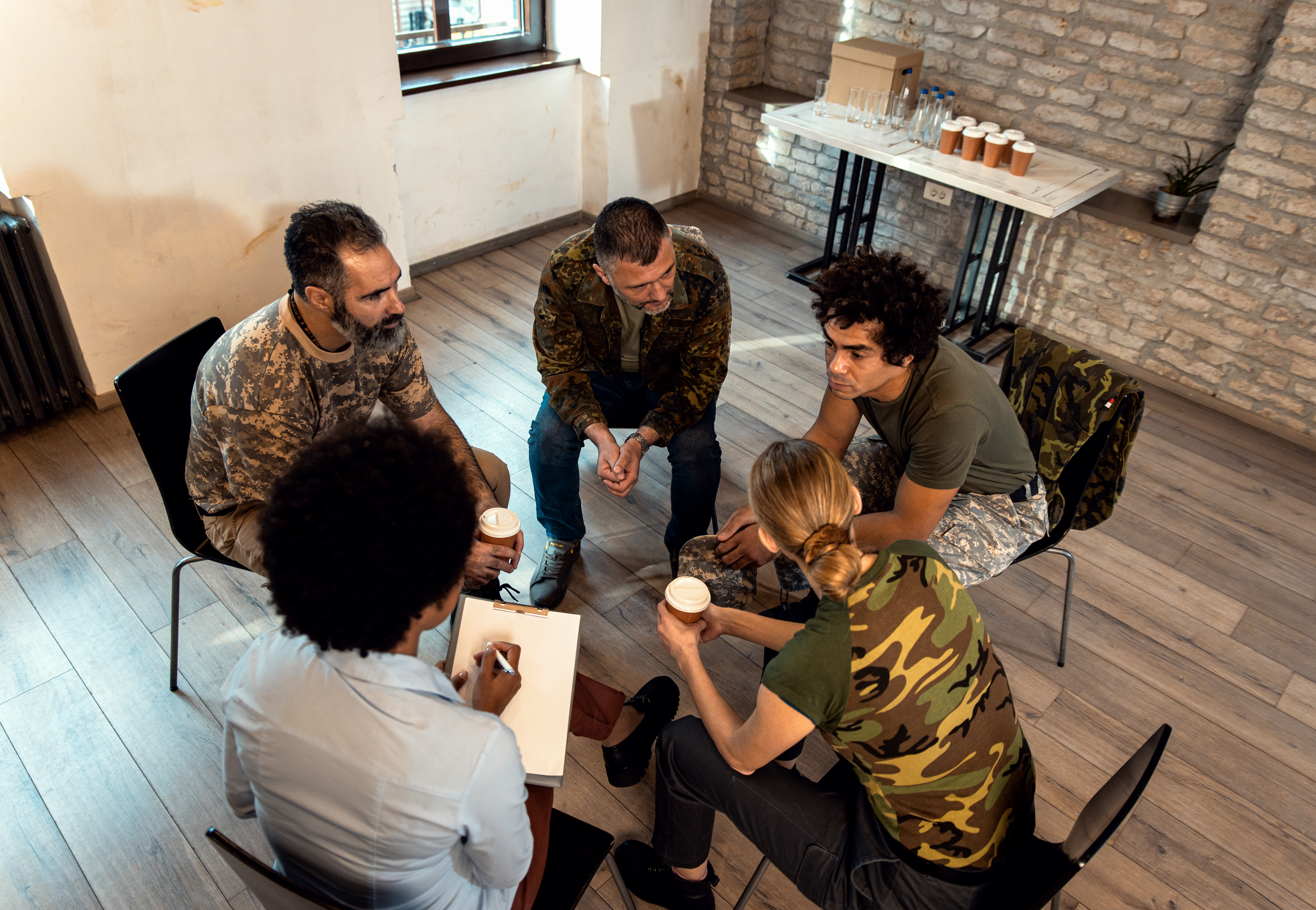 Group of diverse veterans talking during PTSD support group