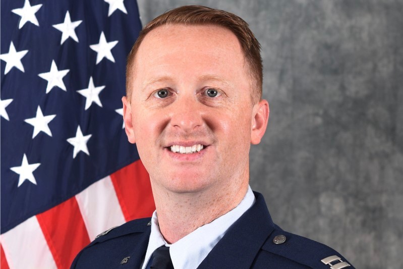 Professional picture of Maj. Marcus Hincks in Air Force uniform in front of the US flag