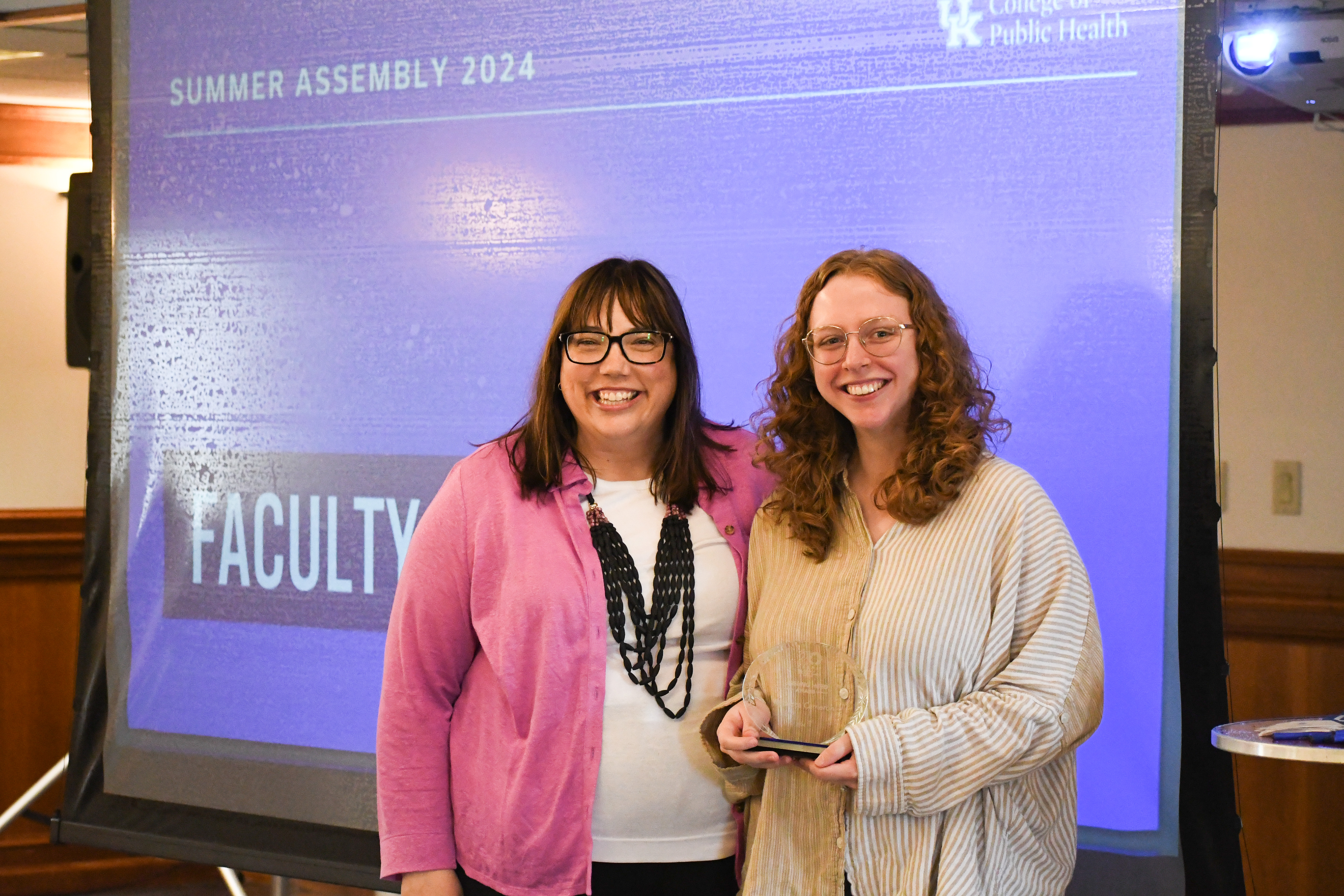 a photograph of Rebecca Cameron accepting her award from Dean Bush