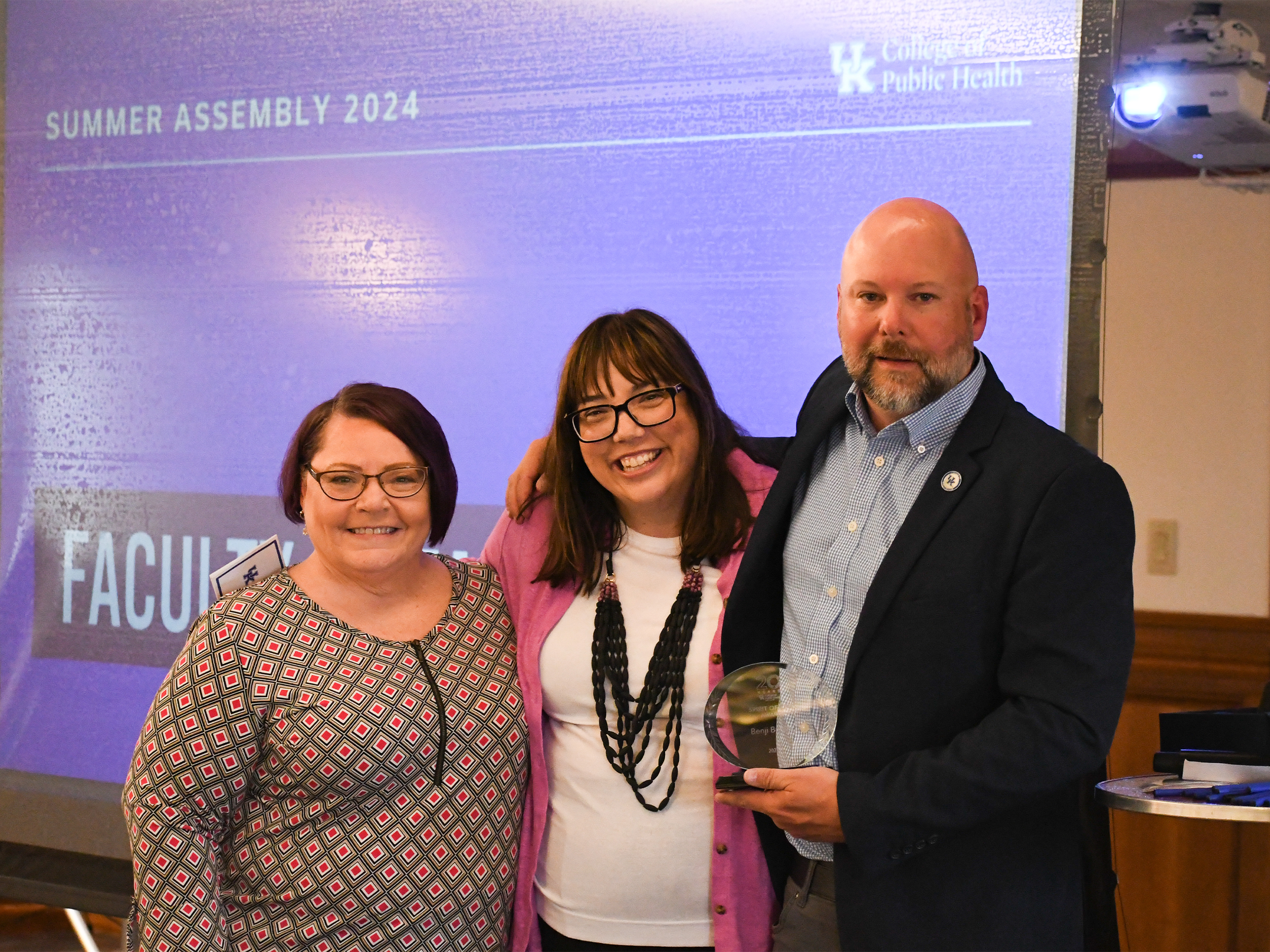 a photograph of Benji Bryant receiving a trophy from Heather Bush