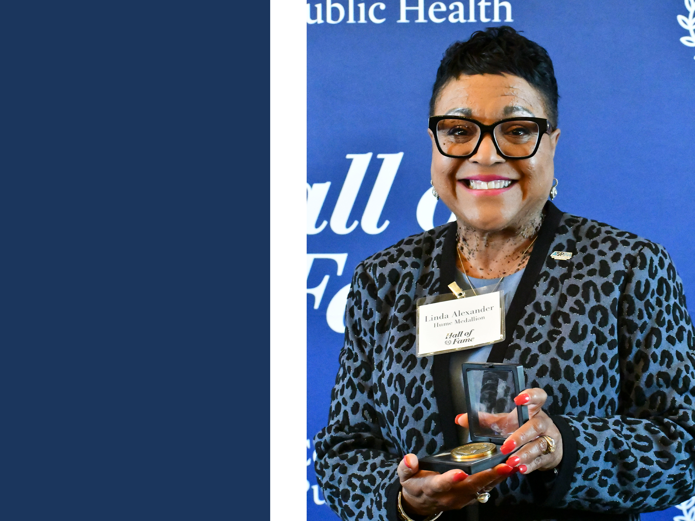 a photograph of Linda Alexander holding their award