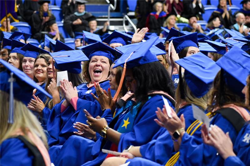 a photograph of CPH students at their graduation excitedly clapping
