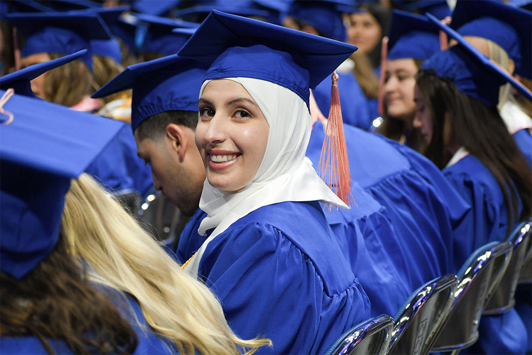 a photograph of a single CPH student sitting at graduation