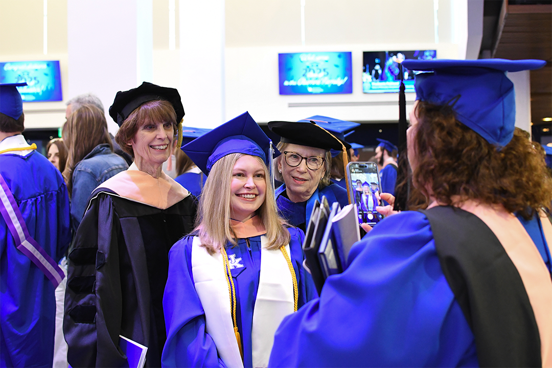 a photograph of a CPH student posing with some faculty members at their graduation