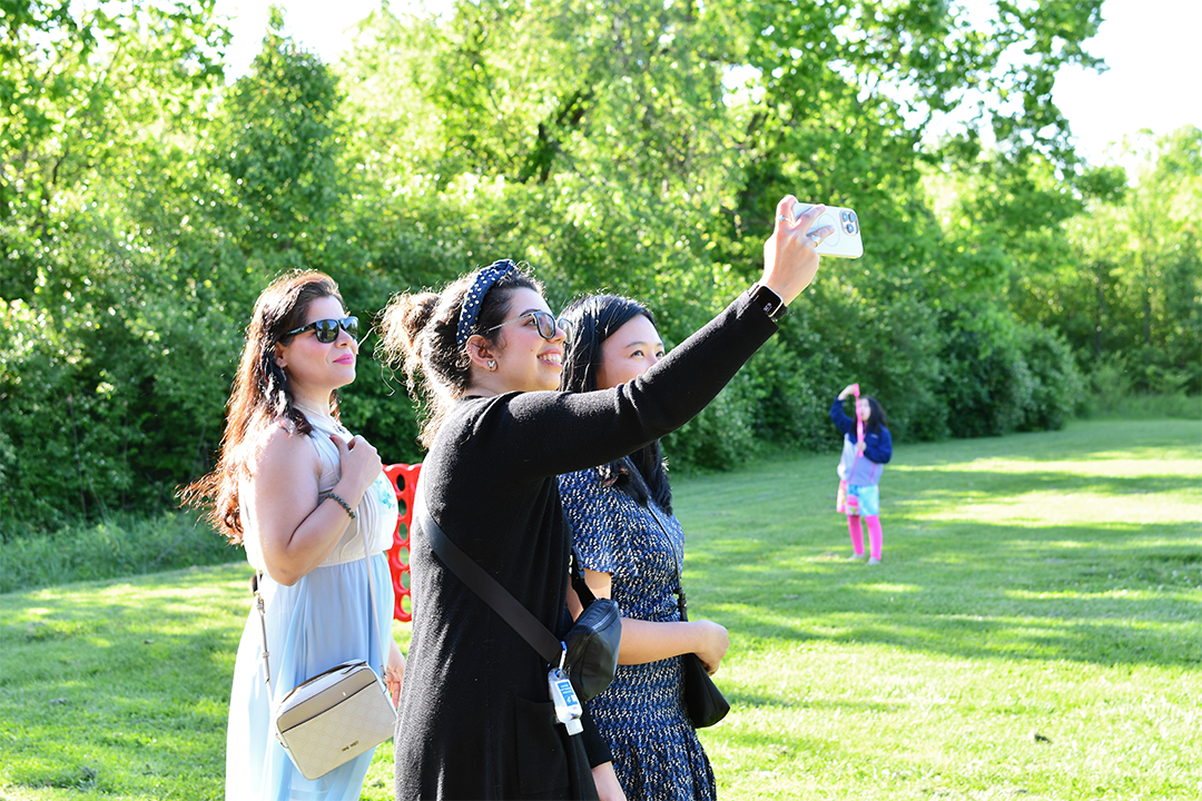a photograph of some students taking a selfie at an outdoor college of public health event
