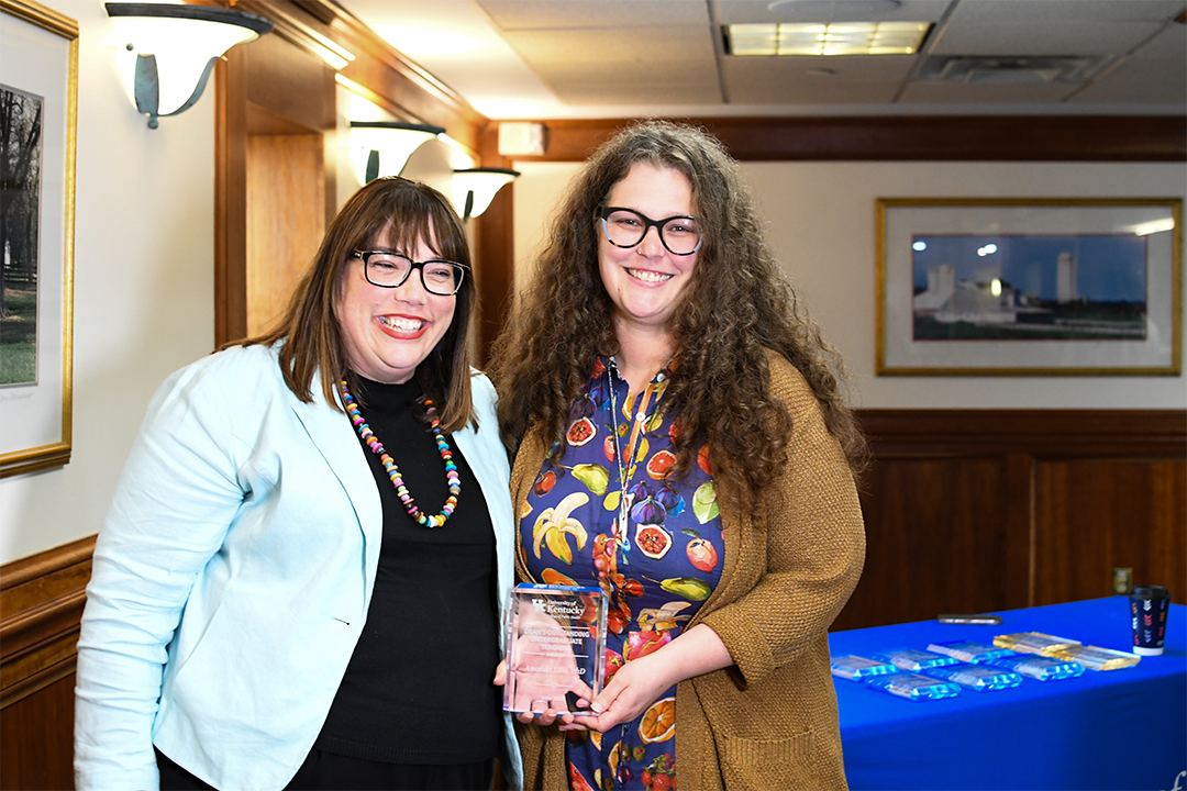 a photograph of Amanda Ellis posing with their award next to Heather Bush