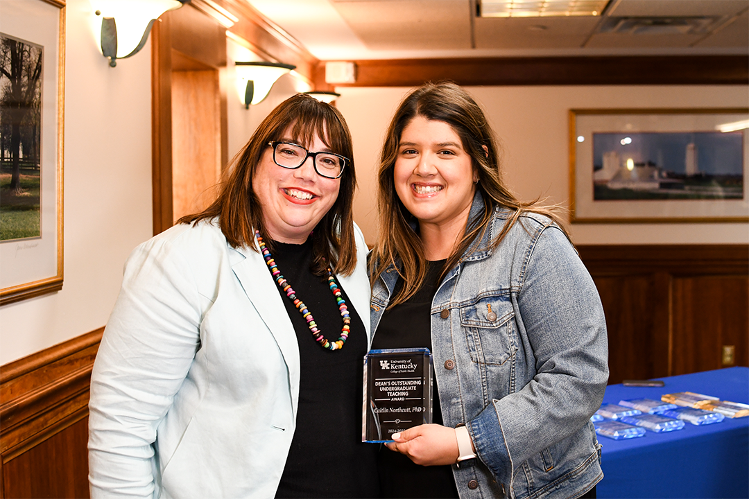 a photograph of Caitlin Northcutt posing with their award next to Heather Bush