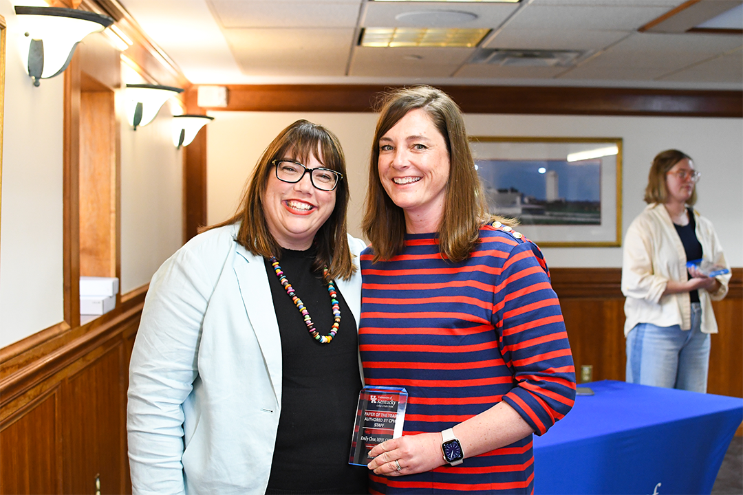 a photograph of Emily Clear posing with their award next to Heather Bush