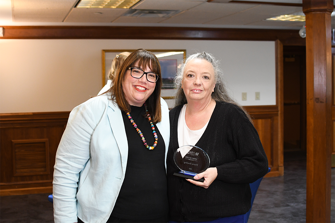 a photograph of Deana Bowling posing with their award next to Heather Bush