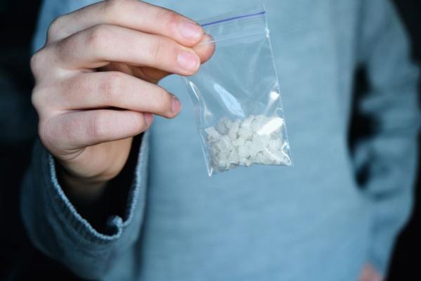 a photograph of someone holding a plastic bag filled with Meth crystals