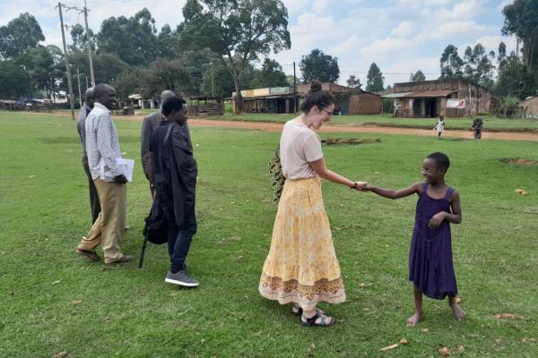 a photograph of Jennifer O'Brien greeting a local on the way to check out a borehole in Ndivisi Market in Kenya