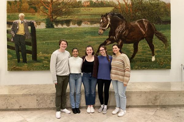 Group picture of Student Public Health Leadership team standing in front of a piece of art