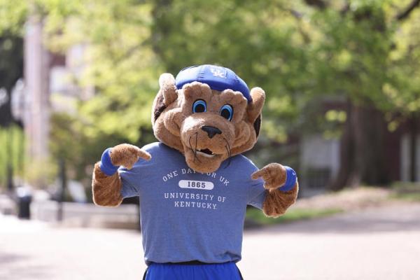 a photograph of the University of Kentucky's mascot wearing a t-shirt stating "one day for UK"