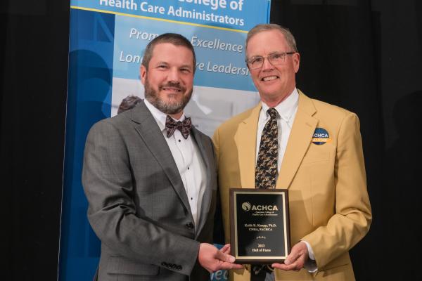 Dr. Keith Knapp (right) receiving plaque award & gold blazer from board chair Matt Lessard (left)
