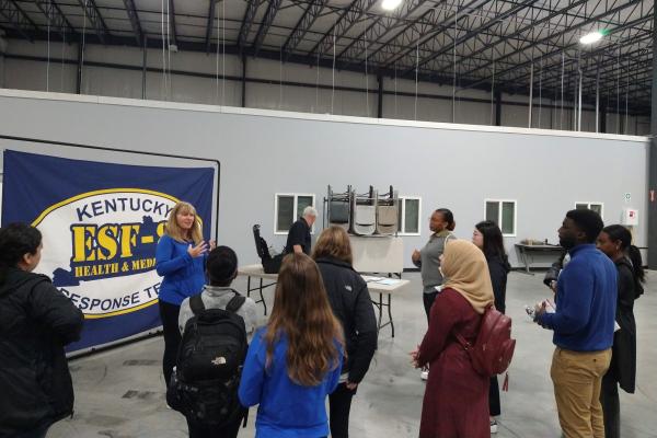 Angela Kick speaking to public health students at the state's operations warehouse