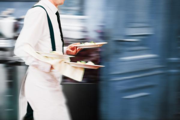a photograph of a waiter serving in motion in restaurant long exposure