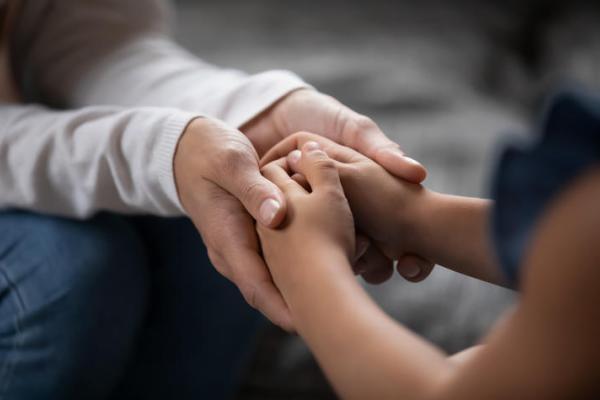 a photograph of an adult holding a child's hands
