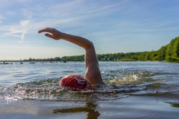 a photograph of a person swimming in a lake