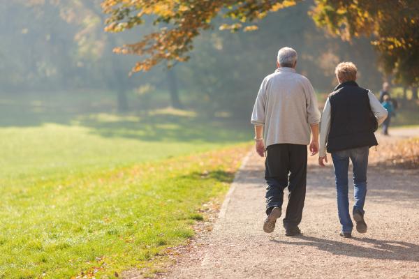 a photograph of two older people walking outside