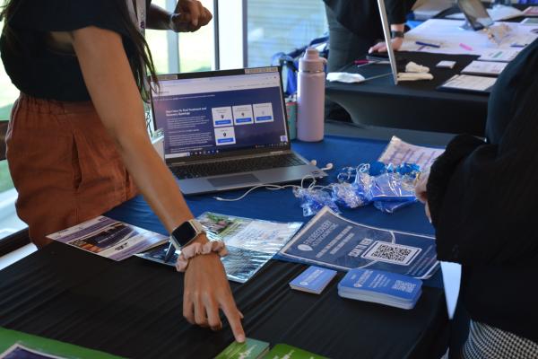 a photograph of a woman pointing to promotional material