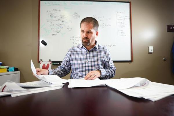 a photograph of David Fardo working at a desk
