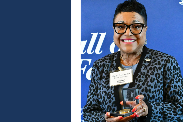 a photograph of Linda Alexander holding their award