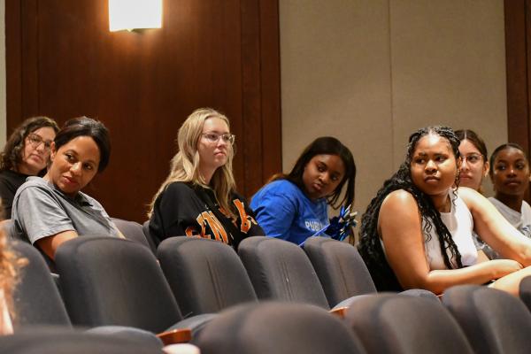 a photograph of students sitting in a classroom watching a speaker