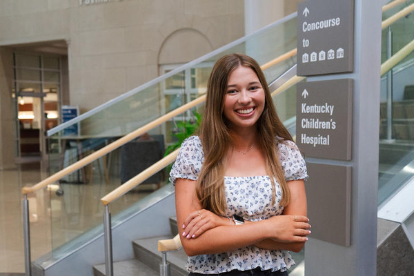 a photograph of Maria Morris posing in the University of Kentucky's hospital entrance