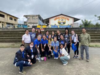 faculty and students pose in front of Ecuadorian housing
