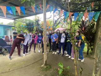 faculty and students pose in a tent outside in Ecuador