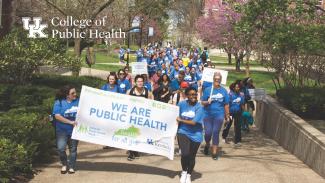 a photograph of students marching with a sign stating "we are public health", with the College of Public Health lockup in the left corner