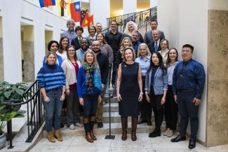 a group photograph of the Health Management & Policy faculty posing on the steps of the William T. Young library atrium