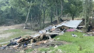 a photograph of a house swept completely into a river