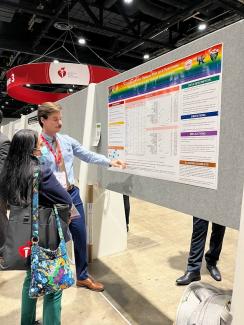 a photograph of Kody Heier presenting their poster during a poster session