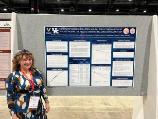 a photograph of Dr. Meredith Duncan standing in front of a research poster