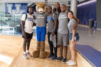 a photograph of students posing with the University of Kentucky wildcat mascot