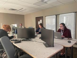 a photograph of students working at individual desks with computers on each