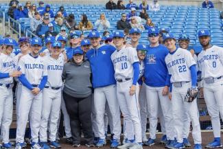 a photograph of Dr. Heather Bush posing with the UK Baseball team
