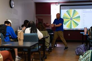 a photograph of Benji Bryant facilitating music bingo activity in a classroom