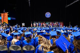 Graduates watching the commencement ceremony at Rupp Arena