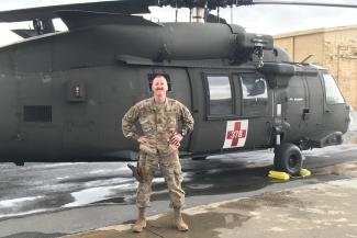 Maj. Hincks standing in front of an Air Force helicopter