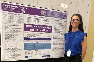 Morgan DeChene pictured in front of research poster about epilepsy awareness and education