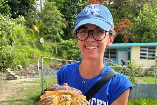 Morgan DeChene pictured in UK baseball cap holding a turtle