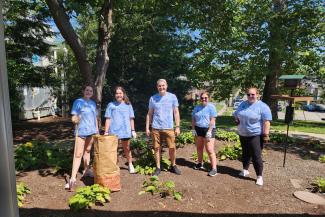 a photograph of students in College of Public Health t-shirts working in a garden