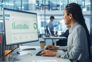 a stock photograph of a person working with data on a computer in an office building