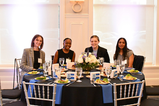 a photograph of atendees sitting at a table for dinner